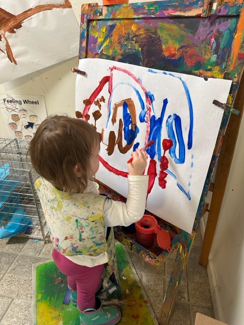 Young child painting at an easel at Mother Lode Mountain Tots Preschool, promoting confidence, friendships, and gentle routines for two-year-olds.